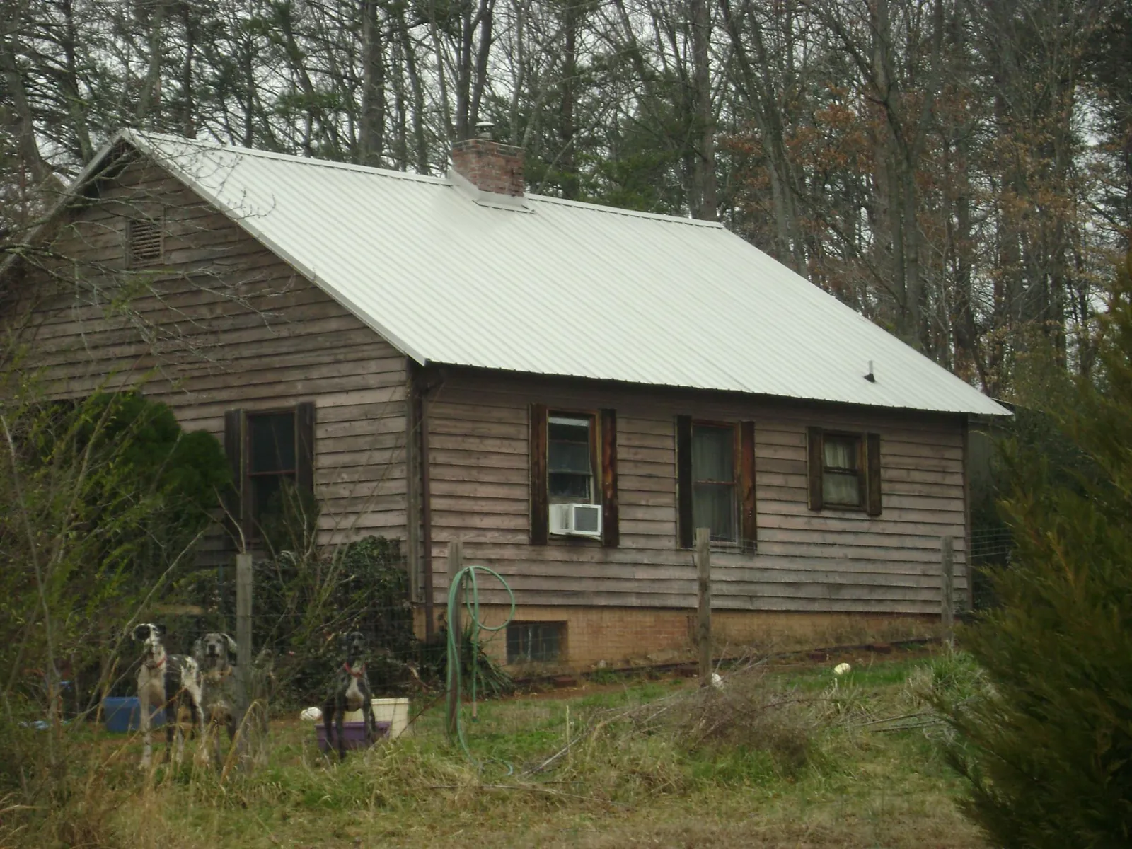 White metal roof on an old wood sided farmhouse, from a Metal Roof Installation job in West Liberty